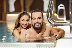 pareja feliz relajándose en el spa de la piscina foto