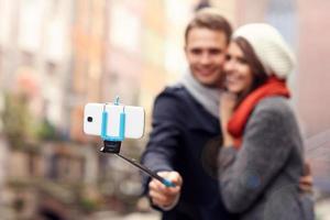 Young couple taking pictures with sefie stick photo