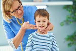 Pediatrician doctor examining little kids in clinic photo