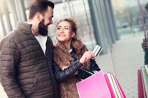 Young couple shopping in the city with credit card photo