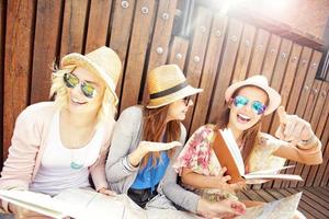 Group of joyful tourists using map in the city photo