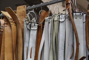 Leather belts in a market photo