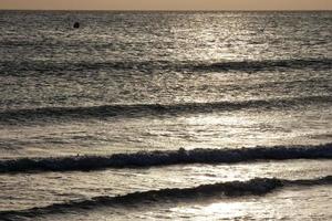 lonely, uncrowded beach with calm sea and small waves photo