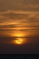 Sun setting over the sea, sunset in autumn on the beach of Zahara de los atunes, Cadiz, Andalucia, Spain photo