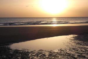 Sun setting over the sea, sunset in autumn on the beach of Zahara de los atunes, Cadiz, Andalucia, Spain photo