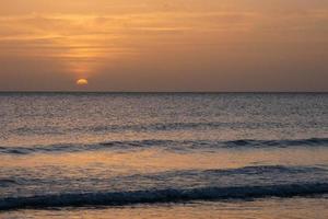 Sun setting over the sea, sunset in autumn on the beach of Zahara de los atunes, Cadiz, Andalucia, Spain photo