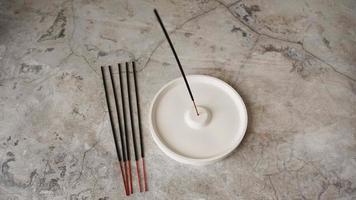 Incense stick in porcelain craft ceramic holder on marble table photo