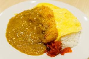 arroz al curry japonés en primer plano en plato blanco con fondo borroso foto