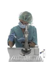 Scientist in blue medical gloves and uniform learning COVID-19 samples with microscope in laboratory. photo