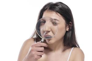 attractive woman looking through magnifying glass photo