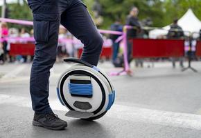 Electric unicycle. Man rides on mono wheel on zebra crossing photo