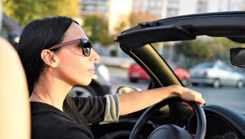 hermosa mujer feliz conduciendo un coche deportivo en la ciudad foto