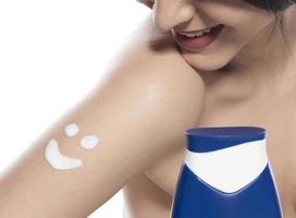 Beautiful skinned woman applying moisturizing cream photo