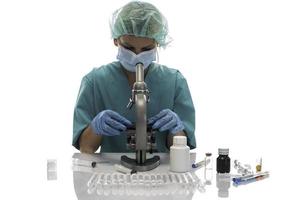 científico con guantes médicos azules y muestras uniformes de aprendizaje covid-19 con microscopio en laboratorio.