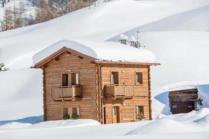 Log cottage nestled in snow photo