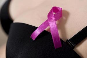 pink ribbon in woman chest to support breast cancer cause photo