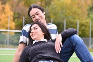 pareja mixta relajándose en el parque foto