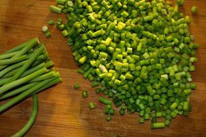 Green garlic on wooden cutting board photo