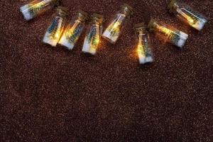 Light bulbs inside with Christmas tree and snow on brown shiny background. Christmas, New Year. Copy space photo