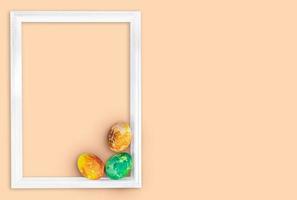 Colored eggs orange and green with frame. Easter concept. Celebration. Copy space photo