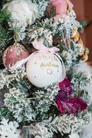 My First Christmas ball ornament hangs from bough of Christmas tree. New Life Christmas and New Year concepts. photo