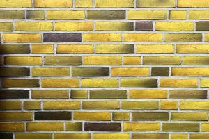Detailed view at a colorful old and weathered brick wall texture as a panoramic background. photo