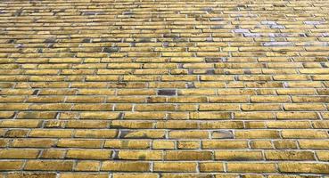 Detailed view at a colorful old and weathered brick wall texture as a panoramic background. photo