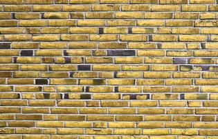 Detailed view at a colorful old and weathered brick wall texture as a panoramic background. photo