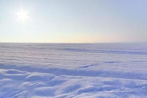 A white snow-covered piece of farmland in winter on a sunny day. photo