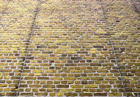 Detailed view at a colorful old and weathered brick wall texture as a panoramic background. photo