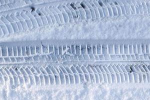 Close up view tire tracks at the surface of fresh fallen snow. photo