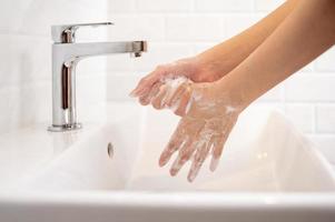 Woman washing her hands  in the bathroom at home