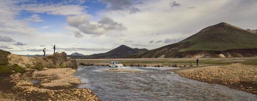 Car crossing shallow river landscape photo