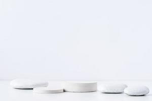 A minimalistic scene of white gypsum podium with stones on white background, for natural cosmetics photo