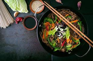 Soba noodles with beef, carrots, onions and sweet peppers photo