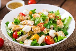 Fresh salad with chicken breast, arugula, lettuce and tomato. photo