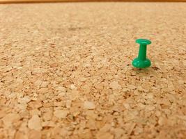 green pin on abstract cork board texture, for the concept of goals and motivation photo