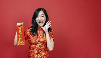 Asian woman holding red fortune blessing Chinese word which means to be blessed by a lucky star isolated on red background for Chinese New Year celebration concept photo