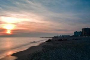 dramática puesta de sol en la playa de coney island foto
