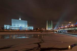 la casa blanca oficialmente - la casa del gobierno de la federación rusa, también conocida como la casa blanca rusa, es un edificio del gobierno en moscú. por la noche a través de un río moskva congelado. foto