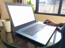 women using laptop computer working at home with blank white desktop screen. photo