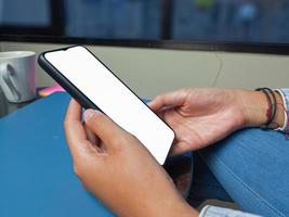 Close-up of a woman hand holding a smartphone white screen is blank .Mockup. photo