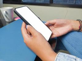 Close-up of a woman hand holding a smartphone white screen is blank .Mockup. photo