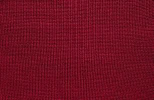 Texture of smooth knitted sweater with pattern. Handmade knitting wool or cotton fabric texture. Background of Large knit pattern with knitting needle or crochet. Color Of The Year 2023 - Viva Magenta photo