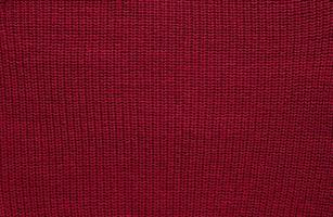 Texture of smooth knitted sweater with pattern. Handmade knitting wool or cotton fabric texture. Background of Large knit pattern with knitting needle or crochet. Color Of The Year 2023 - Viva Magenta photo