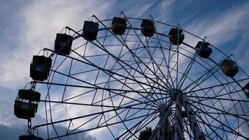 Colorful ferris wheels in the amusement park on a background of blue sky with clouds. Toned image. Bottom view photo