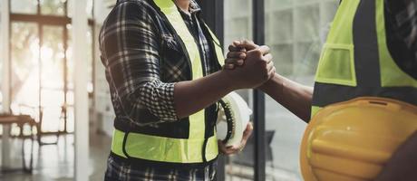 construction worker team hands shaking after consultation meeting to greeting start up plan new project contract in office photo