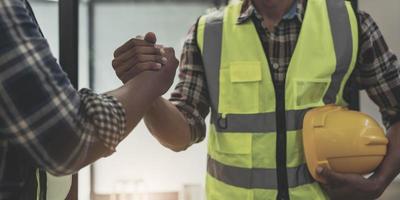 construction worker team hands shaking after consultation meeting to greeting start up plan new project contract in office photo