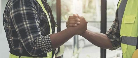 construction worker team hands shaking after consultation meeting to greeting start up plan new project contract in office photo