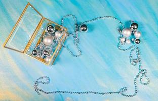 silver Christmas toys and garland on blue background, top view, flat lay, copy space photo